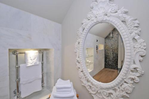 een badkamer met een witte spiegel en een wastafel bij The Barn at Blackbutts in Stonehaven