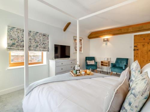 sypialnia z dużym białym łóżkiem i telewizorem w obiekcie Landers Mews w mieście Trunch