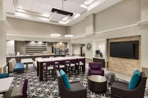 a large waiting room with a bar and a tv at La Quinta by Wyndham Newark - Elkton in Elkton