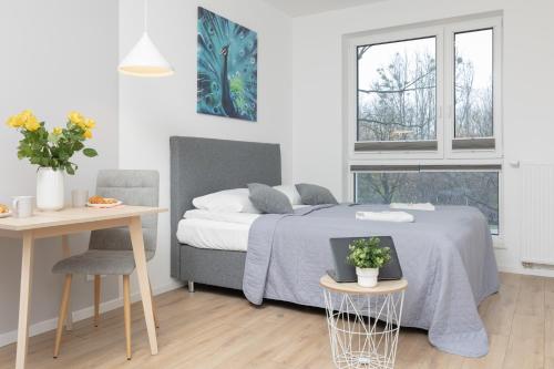 a bedroom with a bed and a table with a laptop at Metro Bielany Apartments with Parking by Renters in Warsaw