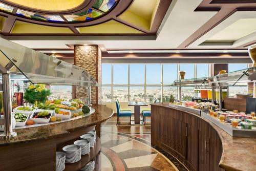 um restaurante buffet com vista para a cidade em Wyndham Garden Dammam em Dammam