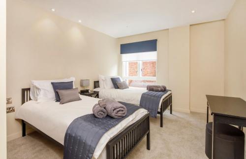 a bedroom with two beds and a desk and a piano at City Apartments - Hudson Quarter with Free Parking in York