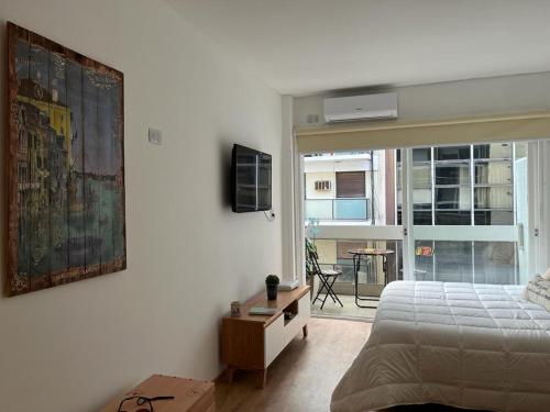 1 dormitorio con cama y vistas a un edificio en Refugio cómodo y luminoso. Excelente ubicación. en Buenos Aires