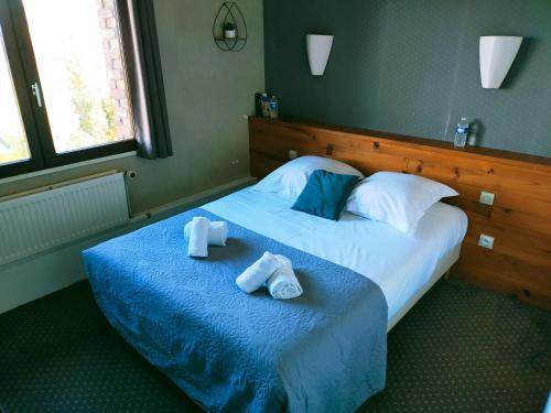 1 dormitorio con 1 cama con 2 toallas en Hôtel Restaurant l’Éolienne, en Rouxmesnil-Bouteilles
