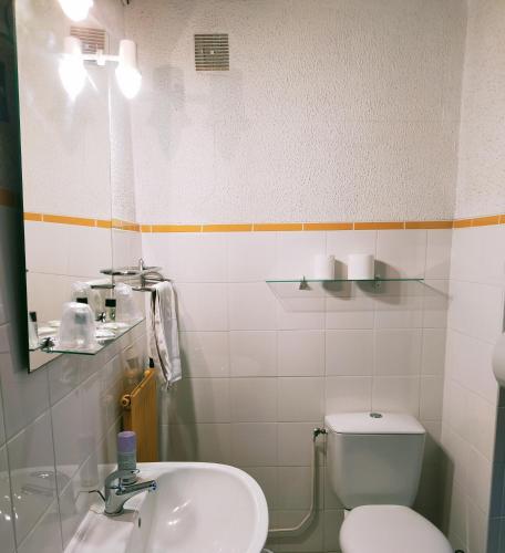 a bathroom with a toilet and a sink at Hôtel Restaurant l’Éolienne in Rouxmesnil-Bouteilles