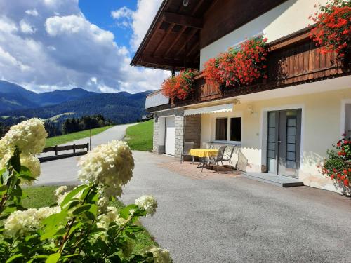 a house with flowers on the balconies and a driveway at Appartement Schilcher in Oberau