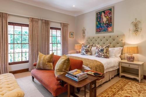 1 dormitorio con cama, sofá y mesa en Ibis House, en Ciudad del Cabo