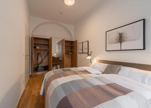 a bedroom with a bed and a picture on the wall at Premium Apartments im Stadtzentrum in Graz