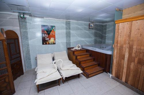 a bathroom with a tub and a pair of towels at AIFU Hotel El Montazah Alexandria in Alexandria