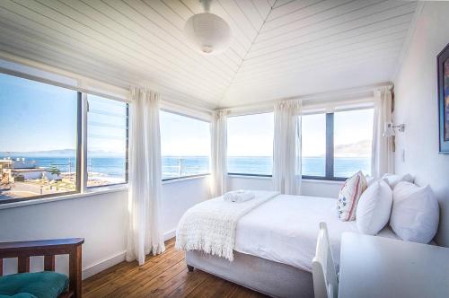 um quarto com uma cama e vista para o oceano em Baytree Beach House em Kalk Bay