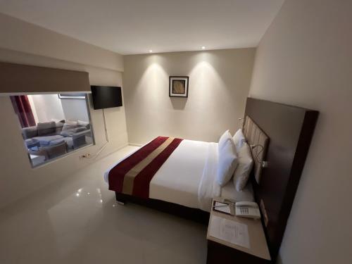 a hotel room with a bed and a mirror at Grand Ocean El Sokhna in Ain Sokhna