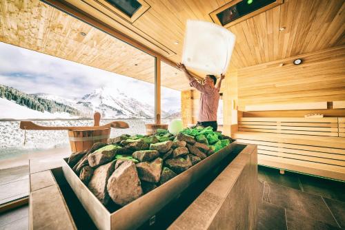 a man standing in a sauna with a pile of vegetables at Wellnesshotel Warther Hof in Warth am Arlberg