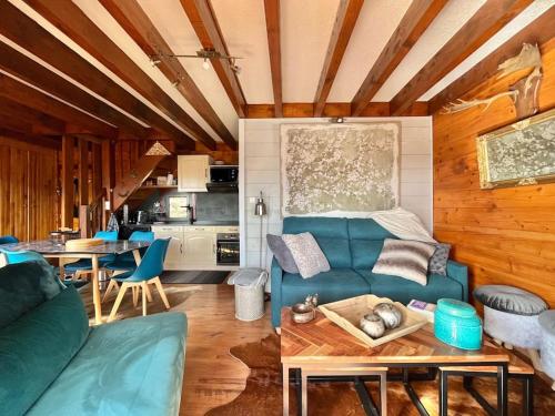 ein Wohnzimmer mit einem blauen Sofa und einem Tisch in der Unterkunft Bolquère I Beau chalet familial proche des pistes in Bolquere