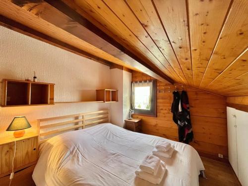 ein Schlafzimmer mit einem großen Bett in einem Holzzimmer in der Unterkunft Bolquère I Beau chalet familial proche des pistes in Bolquere