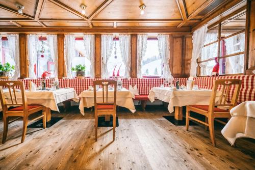 a dining room with tables and chairs and windows at Wellnesshotel Warther Hof in Warth am Arlberg