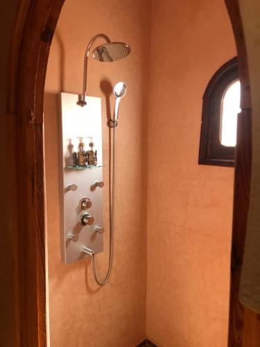 a shower with a shower head in a bathroom at Riad Moha in Merzouga