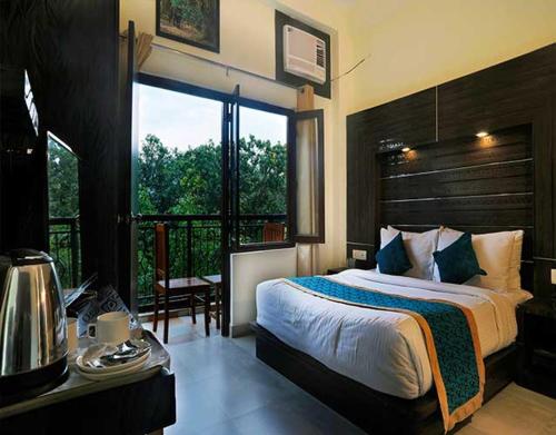 a bedroom with a bed and a large window at Hotel Holiday Highlights in Rāmnagar