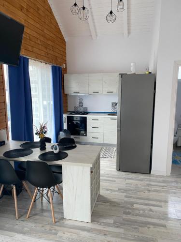 uma cozinha com uma mesa e um frigorífico em Cabana EvAy em Ocnele Mari