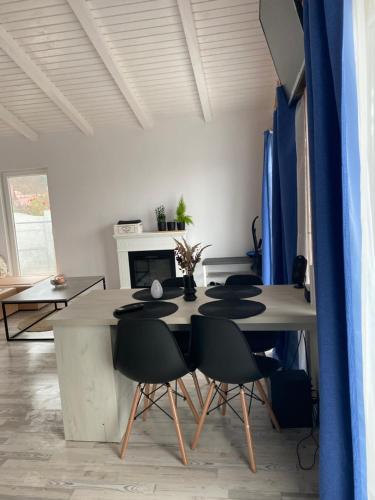 a dining room with a table and black chairs at Cabana EvAy in Ocnele Mari