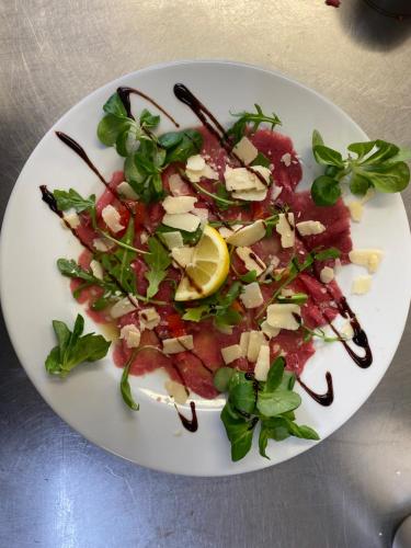a plate of food with a salad on a table at HOTEL L'AMERIVIERE*** in Aubrives