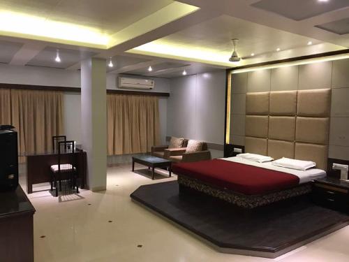 a bedroom with a bed and a couch and a television at Ramakrishna International in Nānded