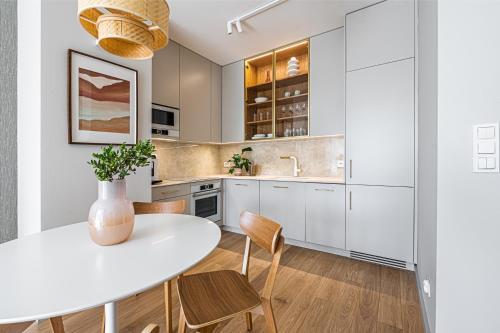 a kitchen with a white table and chairs at Plac Unii Apartament in Gdynia