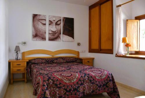 a bedroom with a bed and two pictures on the wall at Casa Regla in Puerto del Carmen