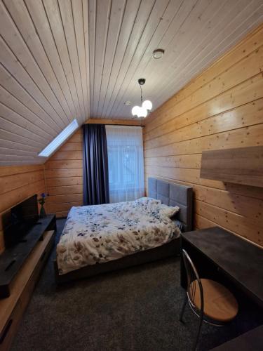 a bedroom with a bed in a wooden room at Baložu rezidence in Jūrmala