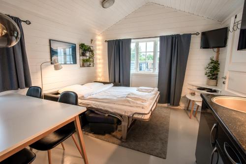 a room with a bed and a table and chairs at Koie Family in Stranda