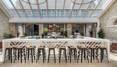 a large white bar with stools in a room at Lazure Hotel & Marina in Herceg-Novi