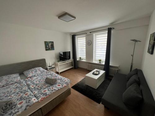 1 dormitorio con cama, sofá y ventana en FW am Park 1, en Holzminden