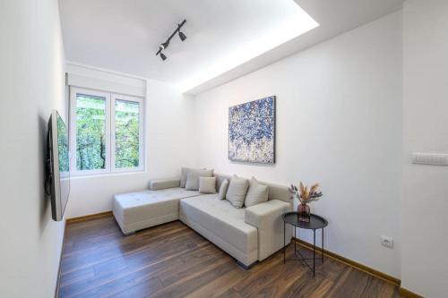 a white living room with a couch and a table at Dedinje apartment in Belgrade