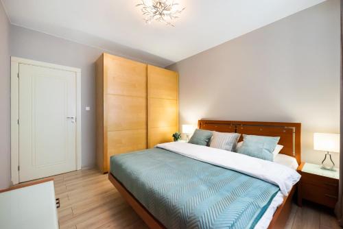 Un dormitorio con una cama grande y una lámpara de araña. en Metro Stokłosy Blue Mint Apartment, en Varsovia