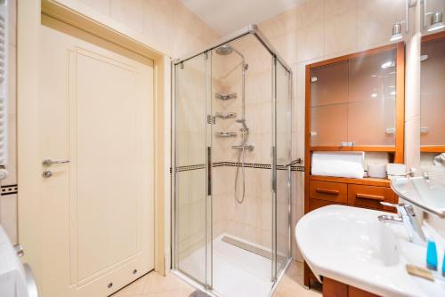 y baño con ducha y lavamanos. en Metro Stokłosy Blue Mint Apartment, en Varsovia