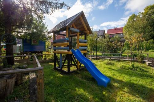 a playground with a slide in the grass at Holiday Home Lana in Fužine