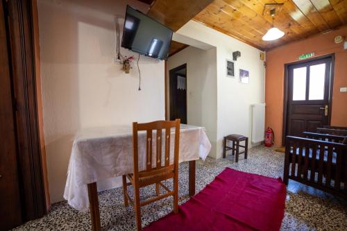 a room with a table and a tv on the wall at Mprizis Rooms in Elati Trikalon
