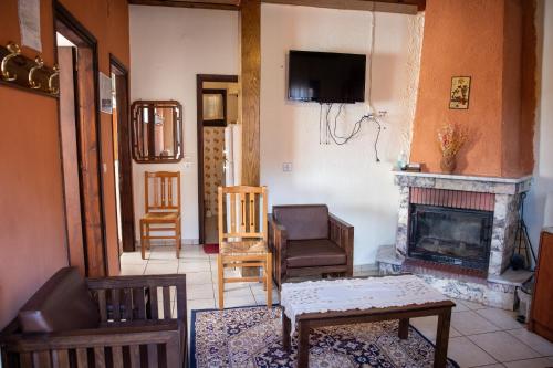 a living room with a fireplace and a tv at Mprizis Rooms in Elati Trikalon