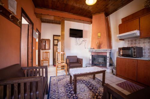 een woonkamer met een tafel en een open haard bij Mprizis Rooms in Elati Trikalon