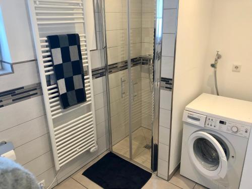 a bathroom with a washing machine and a washer at Ferienwohnung am Teutoburger Wald in Berghagen