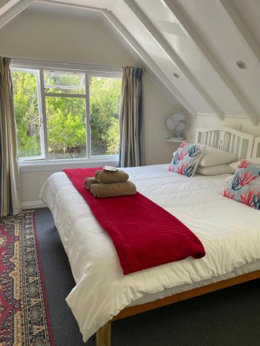een slaapkamer met een groot wit bed en een rode deken bij Beside Still Waters in Wilderness