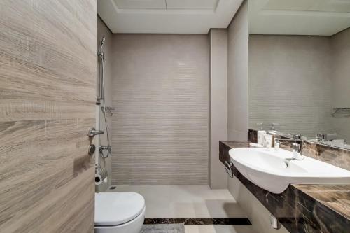 y baño con aseo, lavabo y ducha. en Primestay - Nasayem Avenue in Mirdif Hills, en Dubái