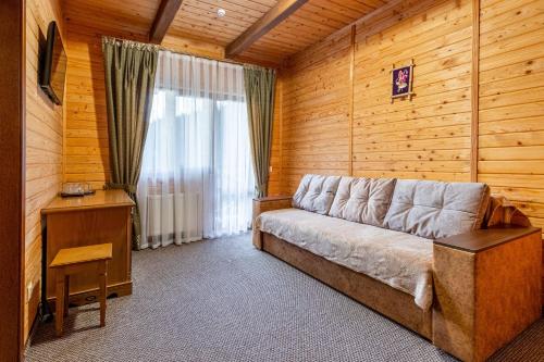 a living room with a couch in a wooden room at Arnika Hotel in Bukovel