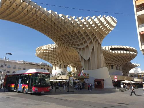un autobús está estacionado frente a un edificio en Imagen Metrosol, en Sevilla