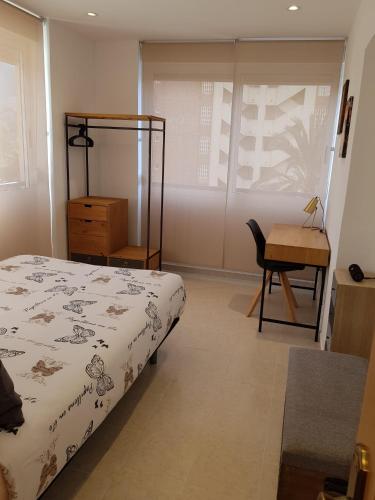 1 dormitorio con cama, escritorio y silla en HR PARADISE RESIDENCIAL LOIX en Benidorm
