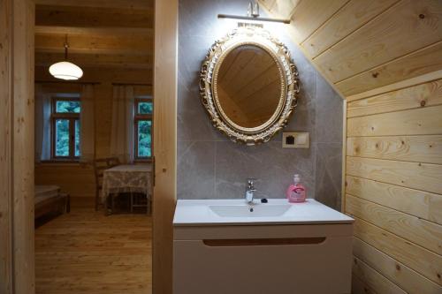łazienka z umywalką i lustrem na ścianie w obiekcie Organistówka w Rabce