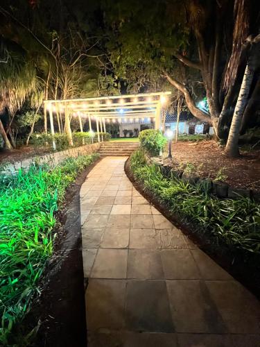 a walkway in a park at night with lights at The Sunbird Guesthouse in Gingindlovu