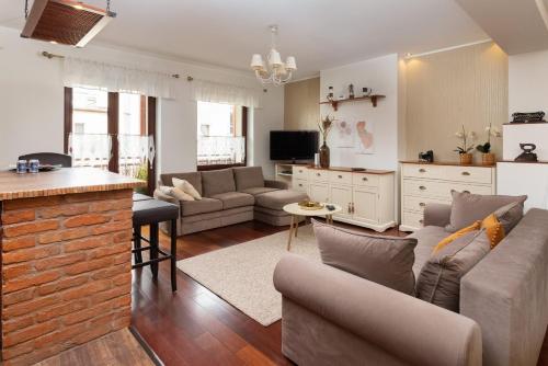 un salon avec deux canapés et une cuisine dans l'établissement Gdynia Centrum Apartament przy Promenadzie by Renters, à Gdynia