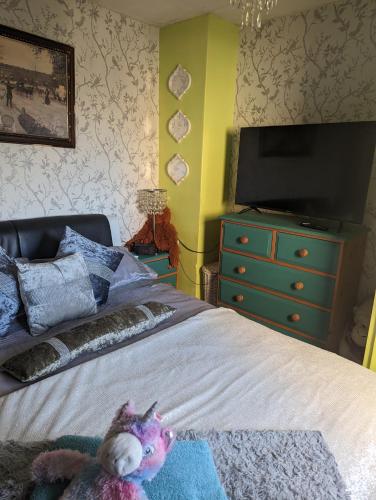a bedroom with a bed with a tv on a dresser at Quaint & Quirky House Colchester Town Centre in Colchester