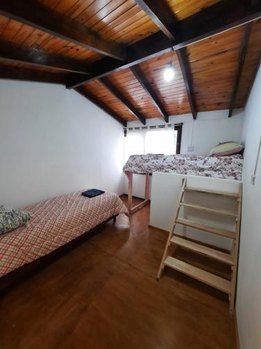 um quarto com duas camas e uma escada em El Balcon em Ushuaia