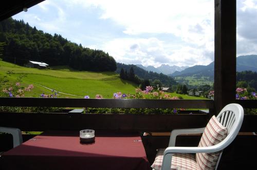 a table and chairs on a balcony with a view at Gschwenderhaus Ferienwohnungen in Oberstdorf